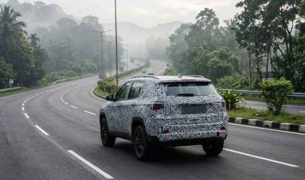 Camouflaged prototype of an upcoming car launch driving on an Indian highway